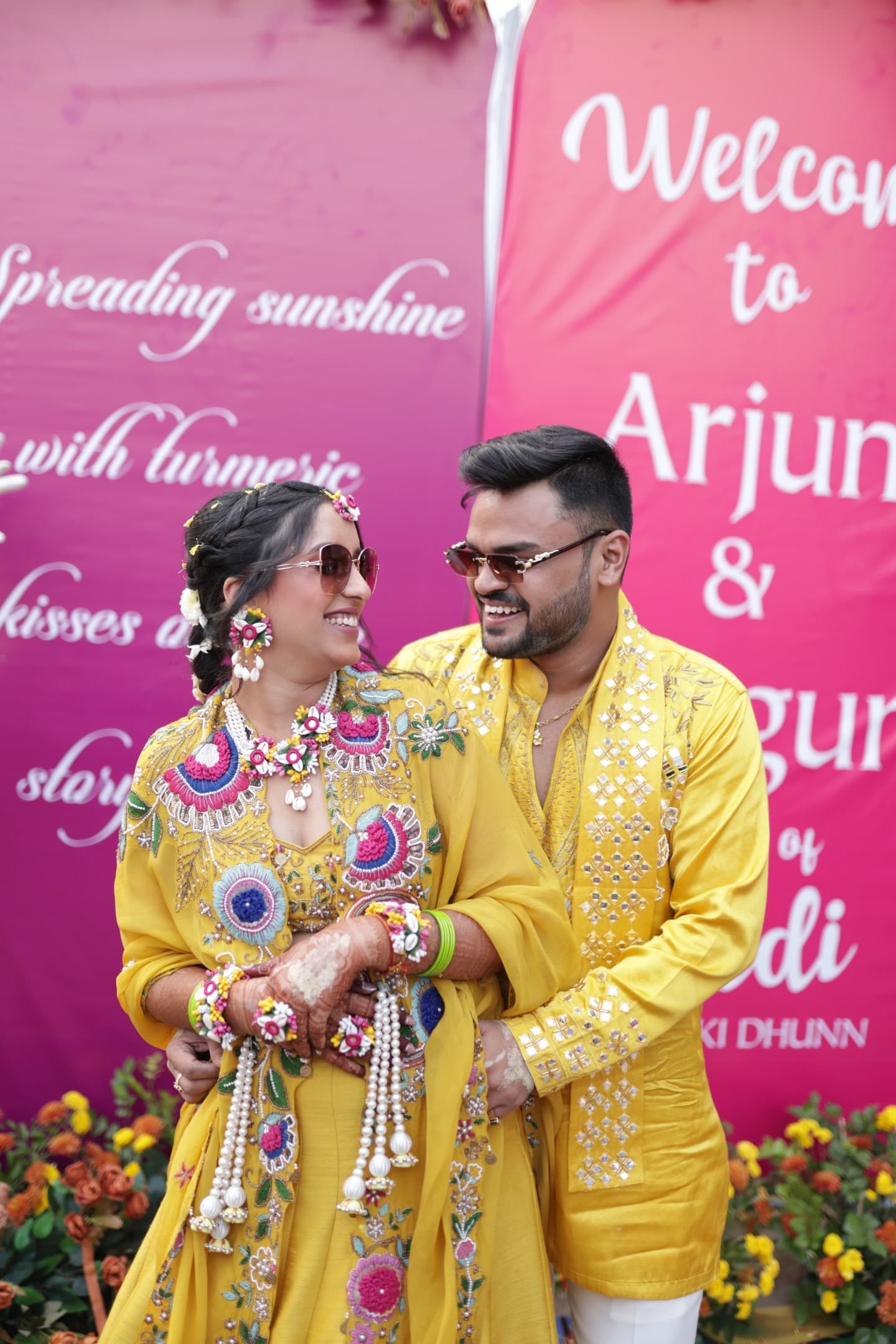 Arjun and Shagun at the Haldi welcome banner in matching yellow outfits