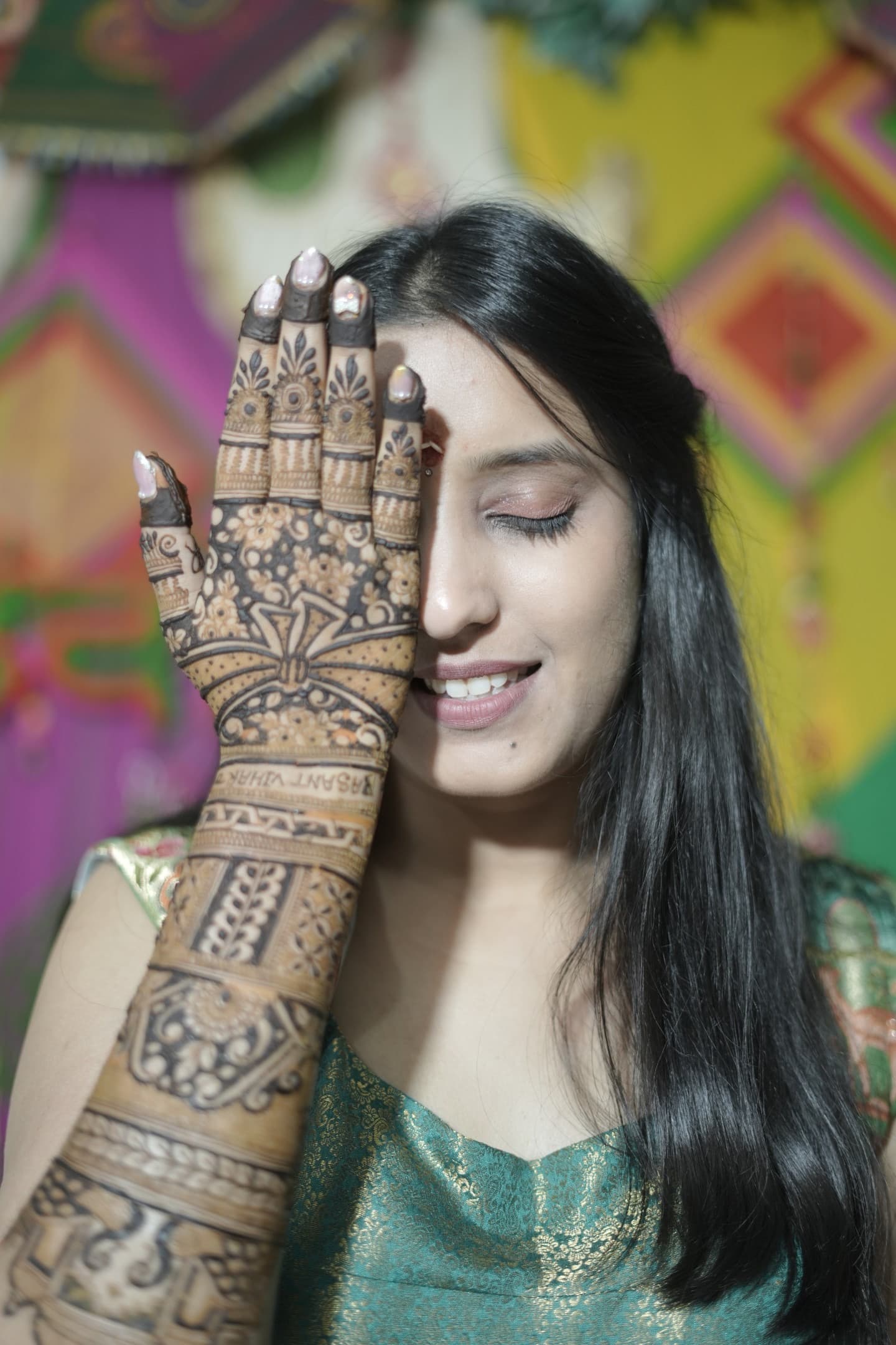 Shagun's bridal mehndi covering her hand and arm, Arjun's name woven into the pattern